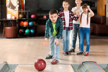 Poster - Little children playing bowling in club