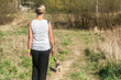 Młoda kobieta na spacerze z psem w lesie podczas kwarantanny
