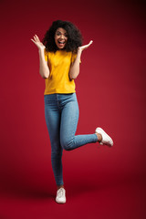 Wall Mural - Full length image of brunette african american woman laughing at camera
