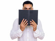 © Ranta Images - Studio shot of young handsome Indian man hiding behind book isolated against white background