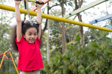 Afro american happiness little girl with curly hair in the playground in summer time with smile and laughing healthy, funny smiling face adorable lovely female kid. happy vacation lifestyle concept.