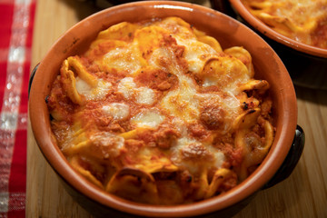 Wall Mural - Baked pasta. Baked orecchiette with bolognese sauce (ragù alla bolognese) and mozzarella in terracotta dish. Italian cuisine. Apulian pasta.