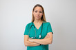 © makyzz - Female nurse standing arms crossed. Confident young woman doctor. Female nurse young pretty woman in green clothes