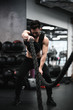 © Mykhailo Feriukov - Man during workout in the gym  Concept: power, strength, healthy lifestyle, sport. Powerful attractive muscular Man CrossFit trainer do battle workout with ropes at the gym. Young man exercising using