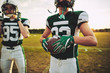 © Flamingo Images - American football quarterback standing with his team on a field