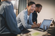 © Flamingo Images - Smiling Asian businesswoman meeting with coworkers in an office