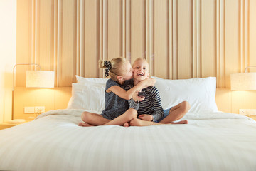 Cute little girl kissing her brother while watching television t