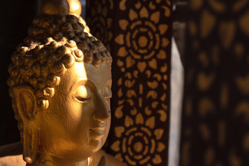 Wall Mural - Golden buddha in Wat Phra That Lampang Luang  in Lampang province, Thailand. Contrast lighting.