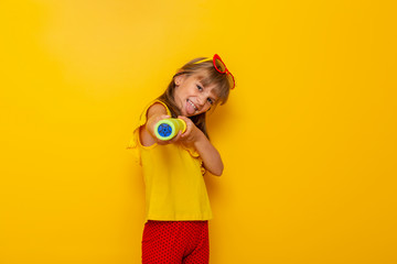 Wall Mural - Child girl playing with water gun