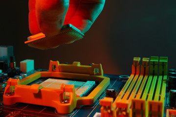 Engineer repairman holding chip CPU to insert into the socket of computer motherboard. Concept of technology hardware.