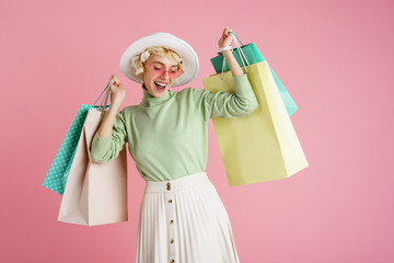 spring shopping concept: happy smiling fashionable woman wearing trendy clothes posing with colorful