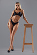 © serhiibobyk - Woman on heels leaning on chair.