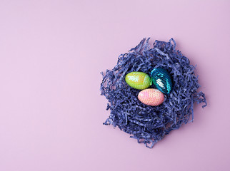 Wall Mural - decorative Easter eggs from sequins lie in a nest of strips of paper