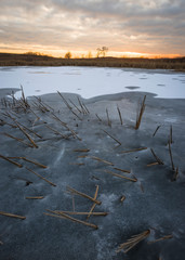 A feeling of tranquility settles over a frozen marsh as sunset color fills the sky.