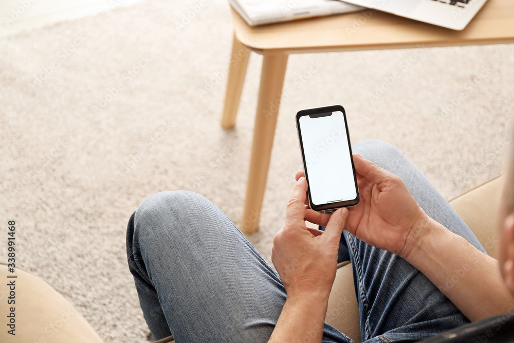 Young man with mobile phone at home