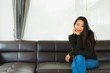 © siraphol - Beautiful portrait young asian woman sit relax on sofa