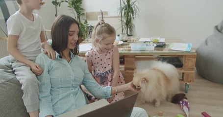 Wall Mural - Happy mom and cute kids using laptop at home