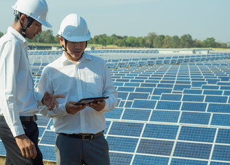 The solar farm(solar panel) with two engineers are talk about the production capacity, Alternative energy to conserve the world's energy, Photovoltaic module idea for clean energy production