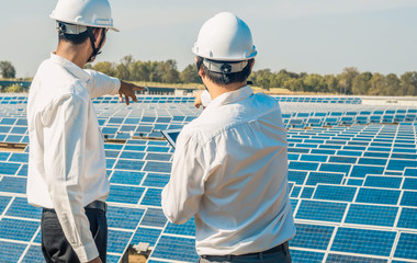 The solar farm(solar panel) with two engineers are talk about the production capacity, Alternative energy to conserve the world's energy, Photovoltaic module idea for clean energy production