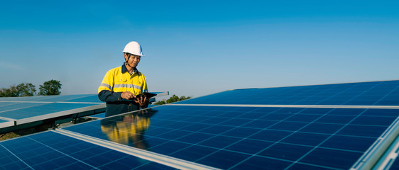 the solar farm(solar panel) with two engineers walk to check the operation of the system, alternativ