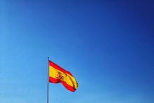 Low Angle View Of Spanish Flag Against Clear Blue Sky