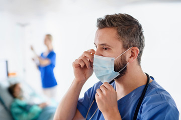 Wall Mural - Doctor with face mask in hospital, coronavirus concept. Copy space.