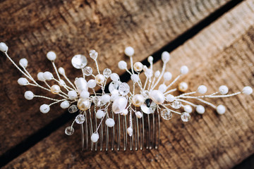 Wedding composition decorated with  pearl jewelry and invitation letter on the wooden table with lace. Jewelry closeup details from morning of the bride.