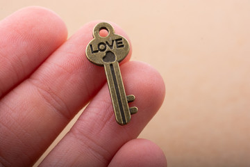 Wall Mural - Heart shaped retro valentine metal key in hand