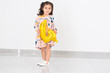 © Inna - Adorable happy brunette little kid girl celebrating her birthday in home. Little child holding golden balloon 4 number on a white background. 4th Birthday celebration party.