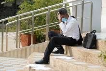 Unemployed Man,Desperate Businessman Sitting Hopelessly On Stair In Central Business District Due To Unemployment From The COVID 19 Disease Situation,Coronavirus Has Turned Into A Global Emergency.