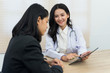 © EduLife Photos - Young Asian female doctor gives consultation and listen to adult female patient’s symptoms in office. Patient having consultation with doctor in office. Medical and healthcare concept.