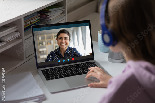 Fotomural Women via videocall talking using webcam pc internet connection, view over girl shoulder
