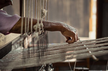 Old Woman Working With Her Hands On A Rustical Loom