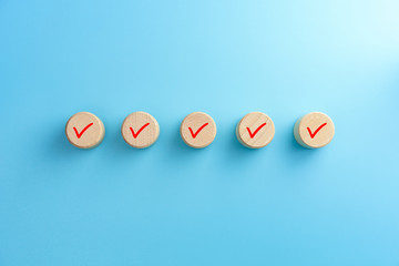 Checklist concept, Check mark on wooden blocks, blue background with copy space