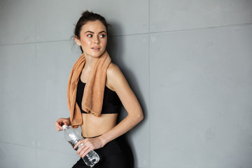 Poster - Photo of pleased woman posing with towel over her neck and water bottle