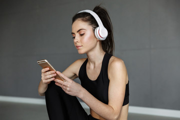 Canvas Print - Photo of nice seductive woman using headphones and mobile phone