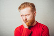 © aeroking - young redhead Man with a beard in shirt feels toothache