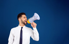 Young Man With Megaphone On Blue Background