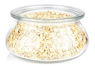 Dry rolled oats in a open transparent glass oval storage jar isolated on white background