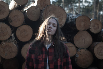 cinematics portrait of a girl against the background of felled trees, the concept of mourning for the destroyed forest.