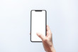 © oatawa - Smartphone mockup. Close up hand holding black phone white screen. Isolated on white background. Mobile phone frameless design concept.