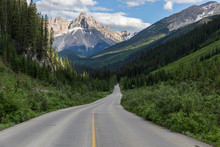 Spectacular Road Landscapes That Run Through Pine Forests And High Mountains, Canadian Roads With The Yellow Lines
