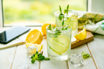 Wall Mural - Summer lemonade in glasses in front of window, copy space