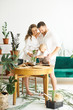 © jul14ka - Happy family working at home. Transplanting plants with their child