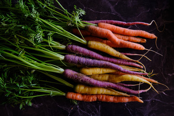 Colorful carrots, healthy vegetables on a black marble background