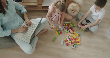 Wall Mural - Happy mom and cute kids using laptop at home