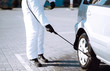 © maxbelchenko - Man in protective suit washing and disinfection car wheels, to preventing the spread of the epidemic of coronavirus, pandemic in quarantine city. Covid-19.