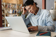 © Drobot Dean - Image of displeased handsome asian man studying with laptop