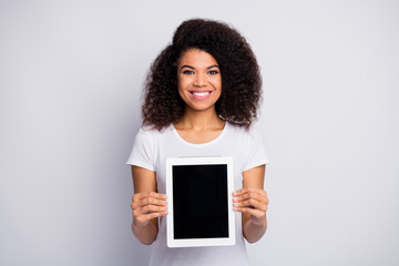 Portrait of her she nice attractive lovely pretty cheerful cheery wavy-haired girl holding in hands showing new digital gadget e-book isolated over light white pastel color background