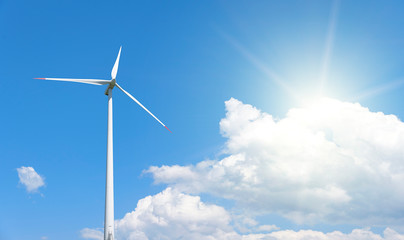 Power generation wind turbines against the blue sky with clouds.